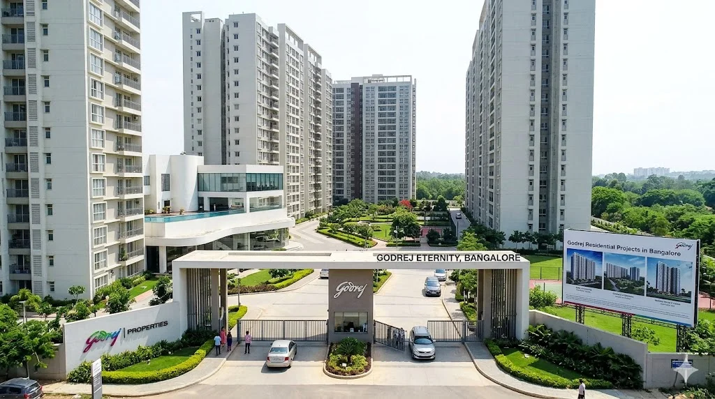 Luxurious high-rise apartment building at a Godrej residential project in Bangalore featuring modern architecture and lush green landscaping.